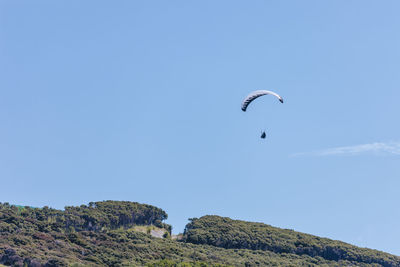 Low angle view of kite flying against clear blue sky