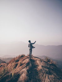 Full length of man standing on mountain against sky