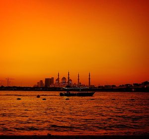 Boats in sea at sunset