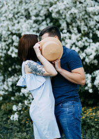 Happy romantic couple in love walking kissing in a blooming spring park