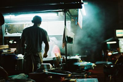 Rear view of chef preparing food in kitchen