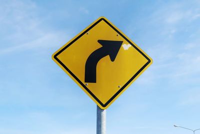 Low angle view of road sign against sky