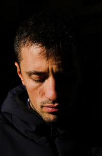 Close-up of young man against black background