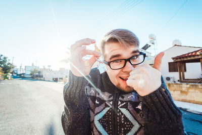 Portrait of young man in city against sky during winter