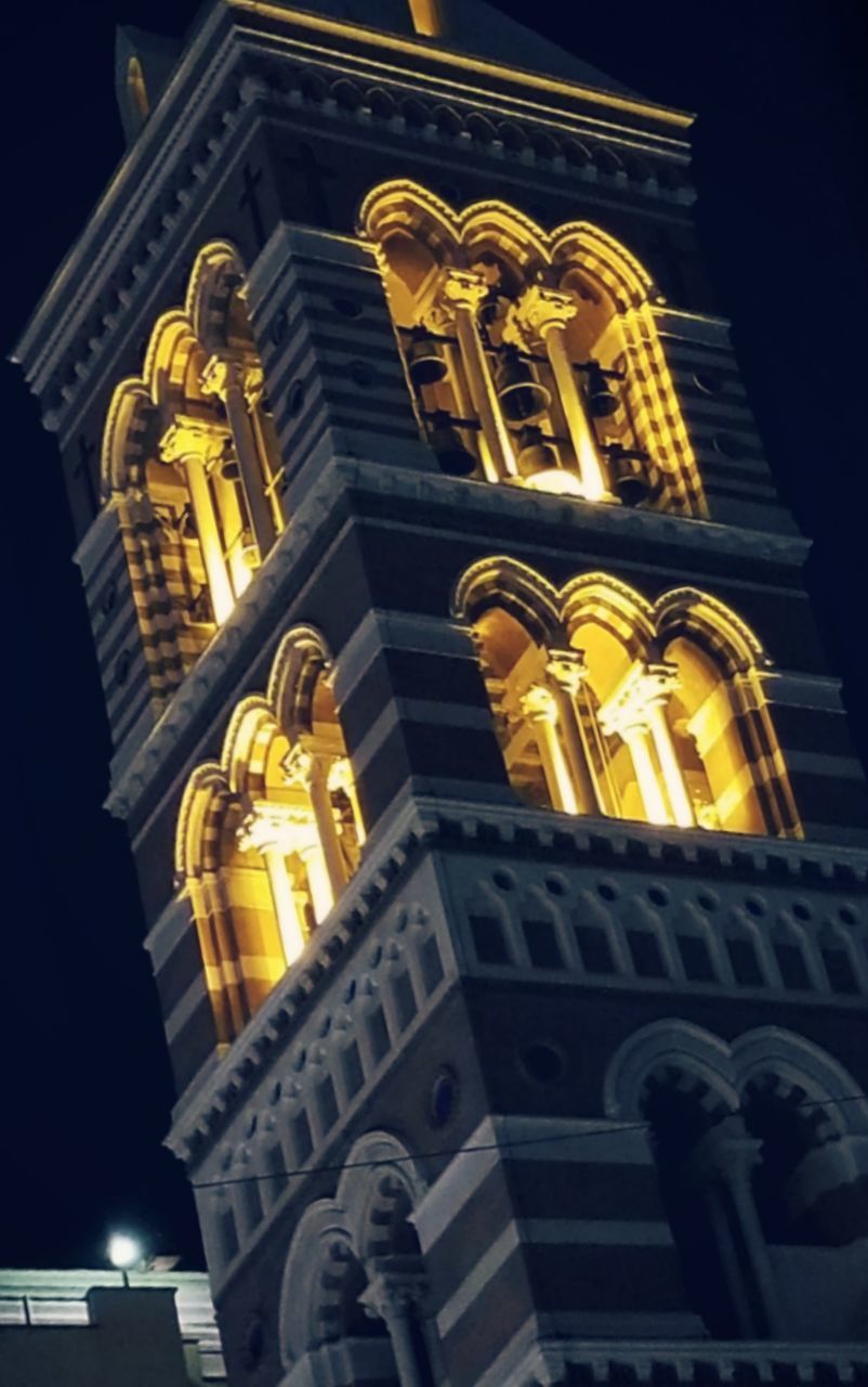 LOW ANGLE VIEW OF ILLUMINATED TEMPLE BUILDING AT NIGHT