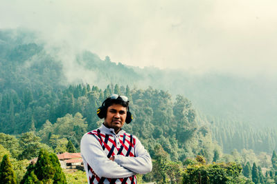 Portrait of young woman standing against mountain