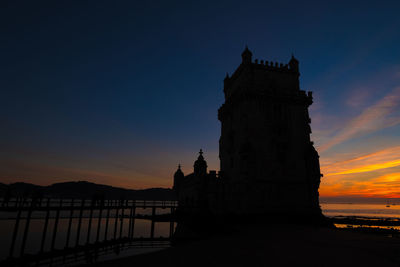 Belem tower silhouette over burning sunset in lisbon portugal 