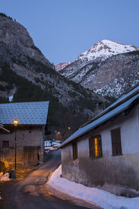 Houses by snowcapped mountains against clear sky