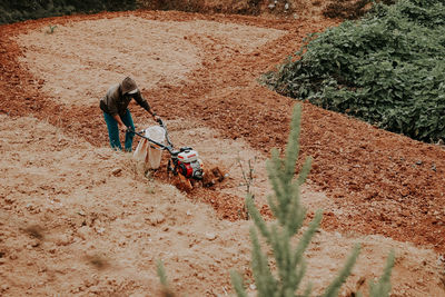 High angle view of farmer plowing field