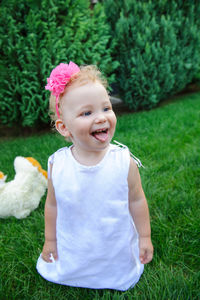 Cute girl kneeling on grass at lawn