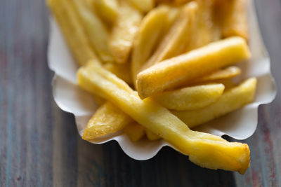 Close-up of french fries in paper plate on table