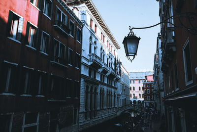 Low angle view of street light against buildings in city