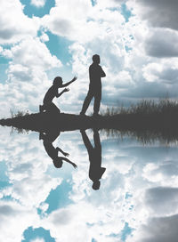 Silhouette couple on field against cloudy sky