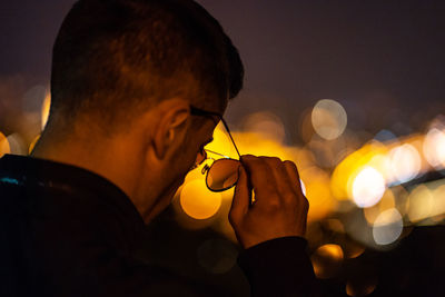 Close-up portrait of young man drinking glass against sky during sunset