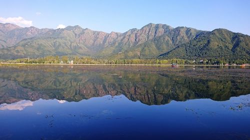 Scenic view of lake by mountains against sky