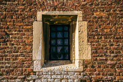 Stain glass window against a brick wall