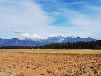 Scenic view of field and mountains against sky