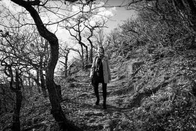 Rear view of woman walking in forest