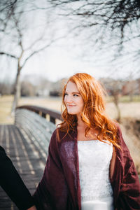 Beautiful young woman standing outdoors on sunny day