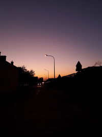 Silhouette of road against sky at sunset