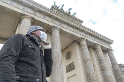 Low angle view of man standing against building