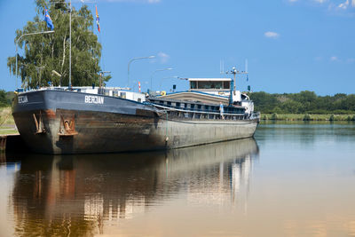 Boat moored on lake against sky