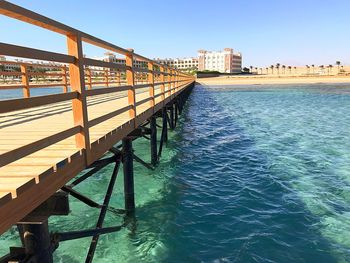 Swimming pool by sea against clear sky