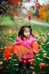 Cute girl standing on field during autumn