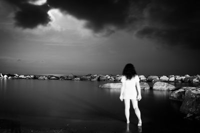 Rear view of woman overlooking calm sea