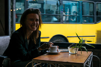 Portrait of young woman drinking coffee in cafe