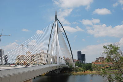 Bridge over river in city against sky