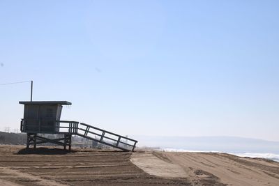 Lifeguard hut on beach against clear sky