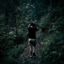 Rear view of woman walking in forest