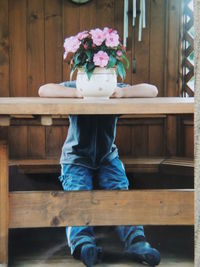 Boy behind vase on table