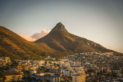 Aerial view of townscape by mountains against clear sky