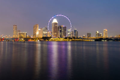 River by illuminated city at night