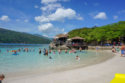 People at beach against sky