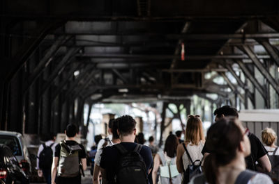 Rear view of people standing on railroad station platform