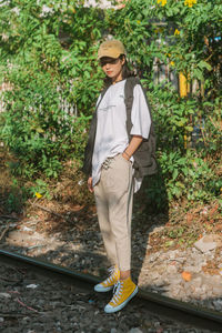 Full length of young man standing against plants