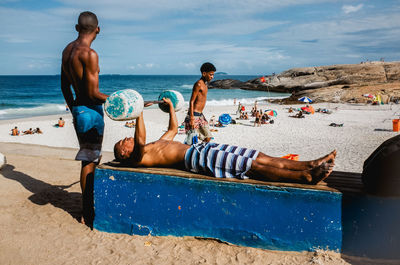 People at beach against sky