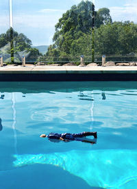 Man swimming in pool by sea