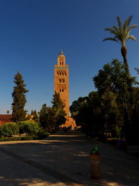 Street amidst trees and buildings against sky