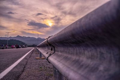 Surface level of road against sky during sunset