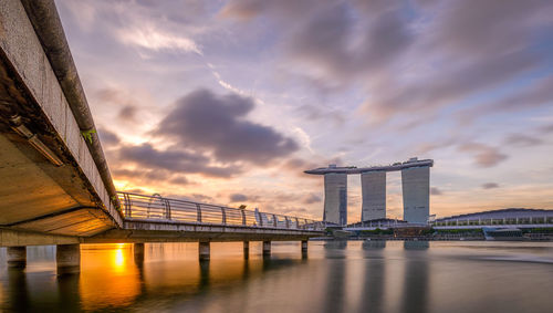 Bridge over river against cloudy sky