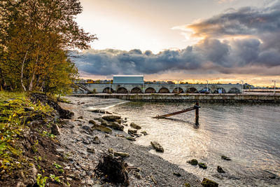 Bridge over river against sky during sunset