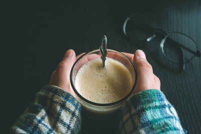 High angle view of hand holding coffee cup