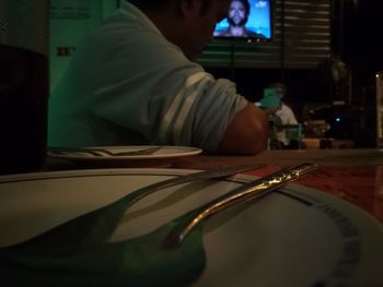 Midsection of man sitting at restaurant table