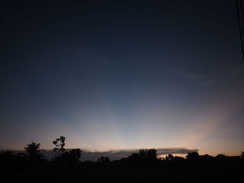 Silhouette trees on landscape against sky at sunset