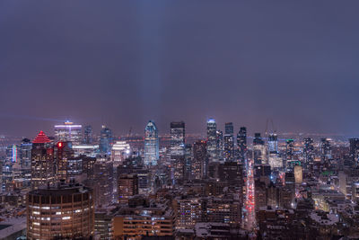 Illuminated cityscape against sky at night