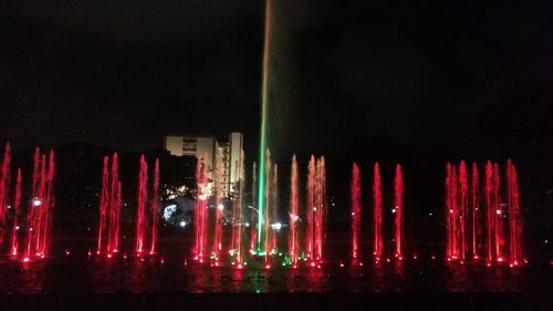 Illuminated modern city against sky at night